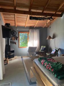 een woonkamer met een bank en een tv bij Quarto/suíte com lareira 