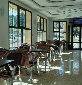 uma fila de mesas e cadeiras num quarto com janelas em TAZEKKA PARC HOTEL em Taza
