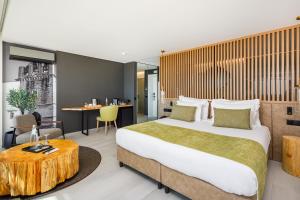 a hotel room with a large bed and a table at AP Eva Senses in Faro