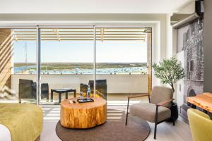 a living room with a coffee table and a large window at AP Eva Senses in Faro