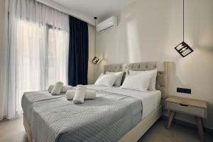 a bedroom with a large bed with white pillows at Mouzaki's Stone Villas in Volímai +37 photos