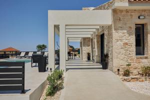 a walkway leading to a house with a pool at Mouzaki's Stone Villas in Volimes