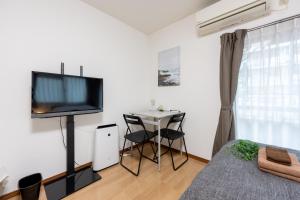 a bedroom with a bed and a table with a television at LUANAHOTEL IN SINNAKANO in Tokyo