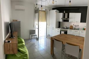 a kitchen with a wooden table and a dining room at Appartamento Fronte Mare con ombrellone e sedie sdraio incluse nel costo in Pescara