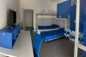 a blue room with two bunk beds and a television at Appartamento Fronte Mare con ombrellone e sedie sdraio incluse nel costo in Pescara