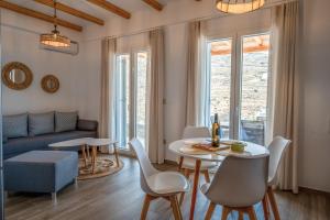 a living room with a table and chairs and a couch at Epithea Suites Kythnos 3 με ιδιωτική πισίνα in Kithnos