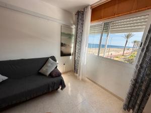 een woonkamer met een bank en een groot raam bij La Vela Playa 2 in Roquetas de Mar