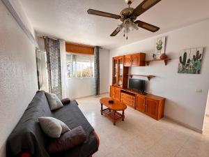 La Vela Playa 2 في روكويتاس دي مار: غرفة معيشة مع أريكة وتلفزيون