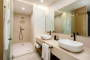 a bathroom with two sinks and a mirror at AP Eva Senses in Faro