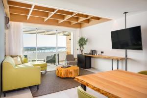 a living room with a tv and a couch and a table at AP Eva Senses in Faro