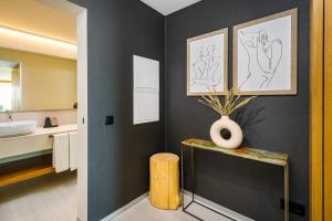 a bathroom with a sink and a vase on a table at AP Eva Senses in Faro