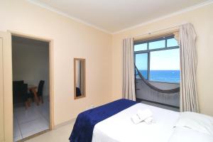 a bedroom with a bed with a view of the ocean at Rio Spot Homes vista praia D047 in Rio de Janeiro