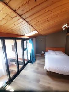 a bedroom with a bed and a large window at L'Atelier in La Rochelle