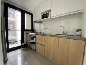 a kitchen with a counter and a sink and a window at Depto Estela - Monoambiente Zona Macrocentro para 2 PAX - Hola Sur in Mar del Plata