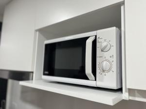 a microwave oven sitting on a shelf in a kitchen at Depto Estela - Monoambiente Zona Macrocentro para 2 PAX - Hola Sur in Mar del Plata