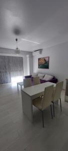 sala de estar con mesa, sillas y sofá en Apartament Ariadna Residence, en Constanţa