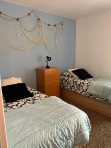 1 Schlafzimmer mit 2 Einzelbetten und einer Kommode in der Unterkunft Apartamento Vacacional en Platja D'Aro in S'Agaró