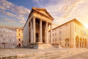 an ancient building with a column in front of a building at Cosy holiday home Infinity with pool and BBQ in Loborika