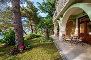 a patio with a table and chairs and trees at House Dinka with Pool in Porat