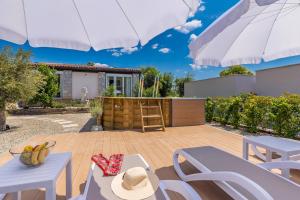 a patio with a table and chairs and an umbrella at Kuća za odmor Villa Seahorse in Pinezici
