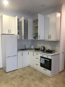 Biała kuchnia z białymi urządzeniami i białymi szafkami w obiekcie Blue Apartment w mieście Gonio