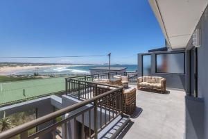 a balcony with chairs and a view of the ocean at Awesome Views & Beach Proximity in Cape St Francis