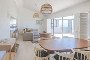 a dining room and living room with a table and chairs at Awesome Views & Beach Proximity in Cape St Francis