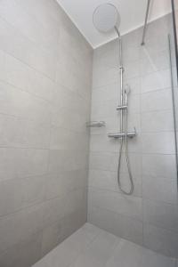 a shower with a shower head in a bathroom at Old Town Hall Suites and Apartments in Athens
