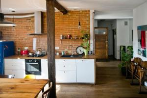 een keuken met witte kasten en een bakstenen muur bij Stylowy, przestronny apartament 80m2 na zielonej ulicy w centrum in Wrocław