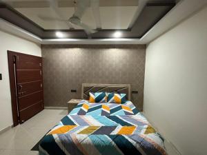 um quarto com uma cama com uma colcha colorida em SunRays - Unique 3BHK in the Heart of the City em Gwalior