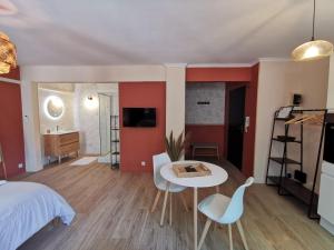 1 dormitorio con 1 cama, mesa y sillas en Studio confort - clim - ascenseur, en Cavaillon