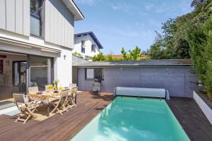 a patio with a table and chairs and a swimming pool at Beautiful villa with heated swimming pool - Biarritz - Welkeys in Biarritz