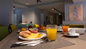 une table avec une assiette de nourriture et deux verres de jus d'orange dans l'établissement Il Santo Stays, à Florence