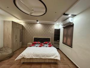 Un dormitorio con una cama con almohadas rojas. en SunRays - Unique 3BHK in the Heart of the City en Gwalior