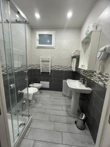 un bagno con due wc, un lavandino e una doccia di B&B Casa Vacanze Nonna Clara a Napoli Altre 24 foto