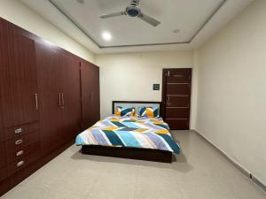 um quarto com uma cama e uma ventoinha de tecto em SunRays - Unique 3BHK in the Heart of the City em Gwalior