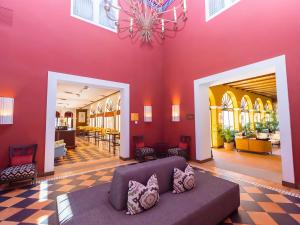 イスラ・カネラにあるIsla Canela Golf Hotel Boutiqueのピンクの壁のリビングルーム(ソファ付)