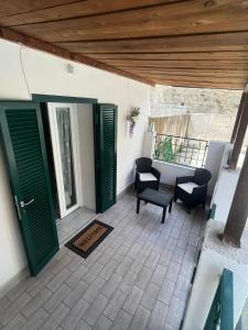 a patio with green doors and a table and chairs at B&B Casa Vacanze Nonna Clara in Naples