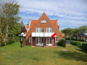 een groot rood bakstenen huis met een groene tuin bij Parkstrasse -Whg1 in Wyk auf Föhr