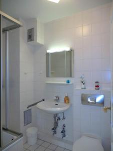 een badkamer met een wastafel, een toilet en een spiegel bij Parkstrasse -Whg1 in Wyk auf Föhr