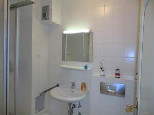 een witte badkamer met een wastafel en een spiegel bij Parkstrasse -Whg1 in Wyk auf Föhr
