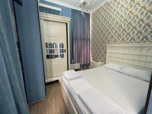 a bedroom with a white bed and a blue wall at HOTEL AiSi აისი in Kutaisi