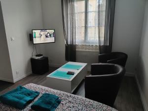 a room with a bed and a table and a tv at Studio Bis Proche centre ville et Canal à Montargis in Montargis