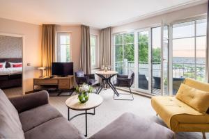 a living room with a couch and a bed at Hotel Residenz Waldkrone Kühlungsborn in Kühlungsborn