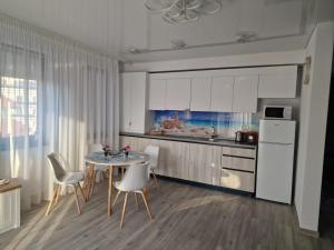 a kitchen with a table and chairs and a refrigerator at Crystal Sands Residence in Eforie Nord
