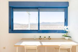 een blauw raam in een kamer met een tafel en stoelen bij Roseville in Puerto del Rosario