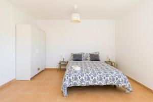 a bedroom with a bed with a blue and white bedspread at Roseville in Puerto del Rosario