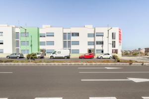 un parcheggio con auto parcheggiate di fronte a un edificio di Roseville a Puerto del Rosario