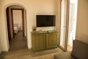 un soggiorno con TV e mobile con TV di Le Casette del Bosco a Favignana