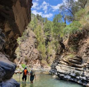 two people walking through a river in a canyon at TAZEKKA PARC HOTEL in Taza
